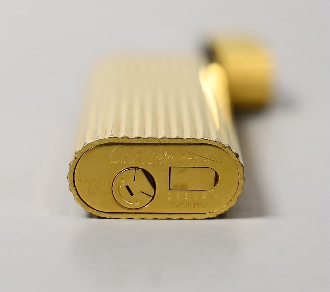 A Must de Cartier gold plated lighter, cased, 7cms long